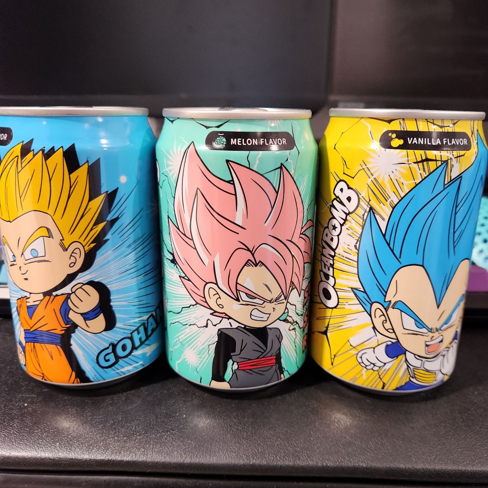 Cans of carbonated flavored sodas but with super saiyan Gohan (grape flavor), super saiyan Goku Black (melon flavor), and super saiyan blue Vegeta (vanilla flavor). 