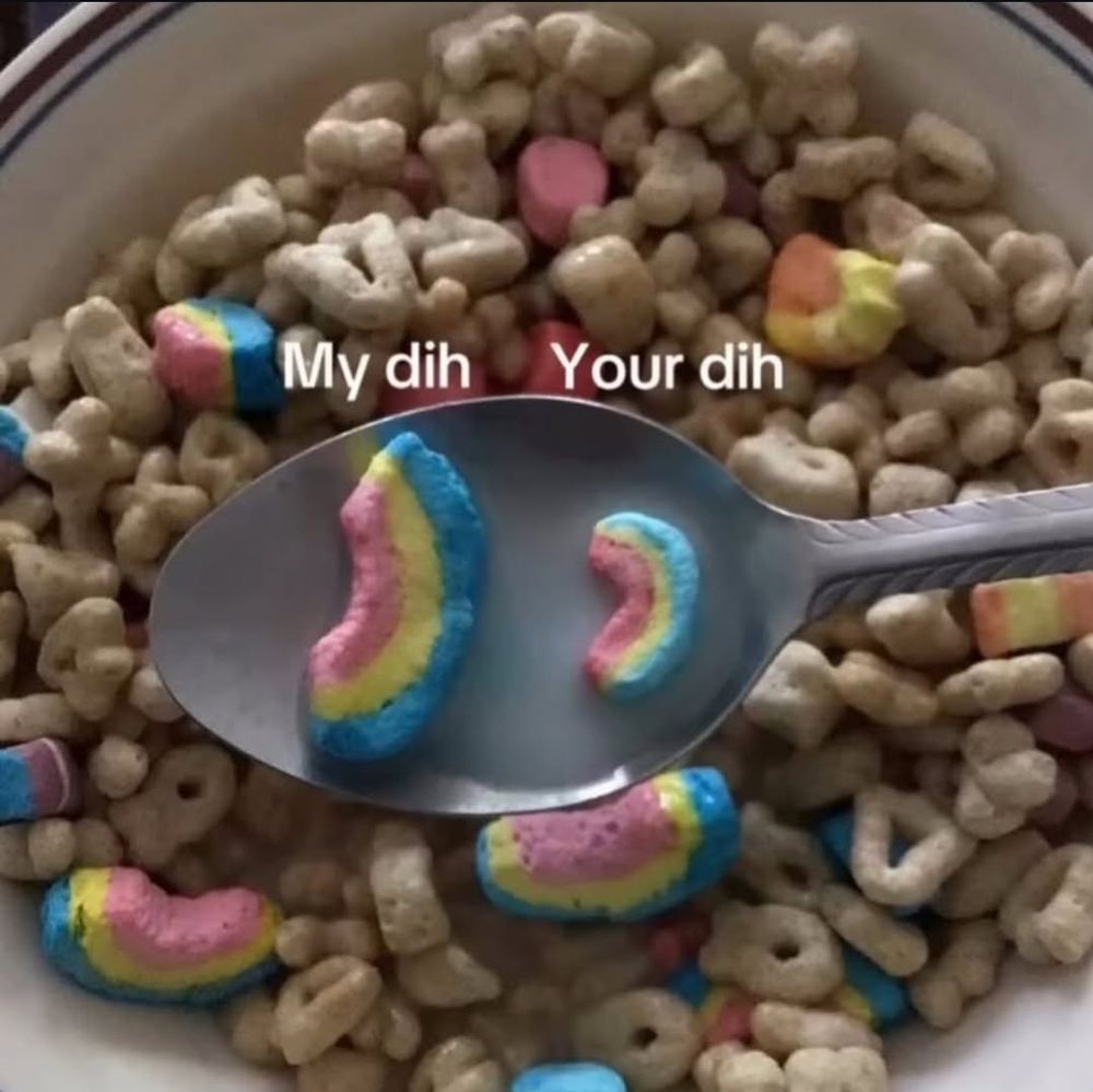 A picture of a spoon holding milk and 2 rainbow marshmallows over a bowl of lucky charms cereal, with one larger rainbow marshmallow labeled "my dih" and the smaller rainbow marshmallow labeled "your dih"