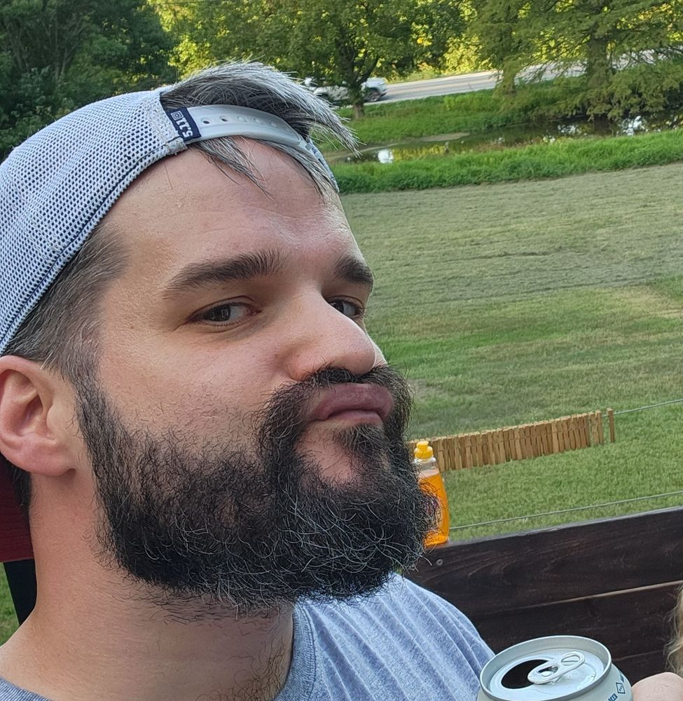 Me, backwards hatted up with a decent beard, holding a beer