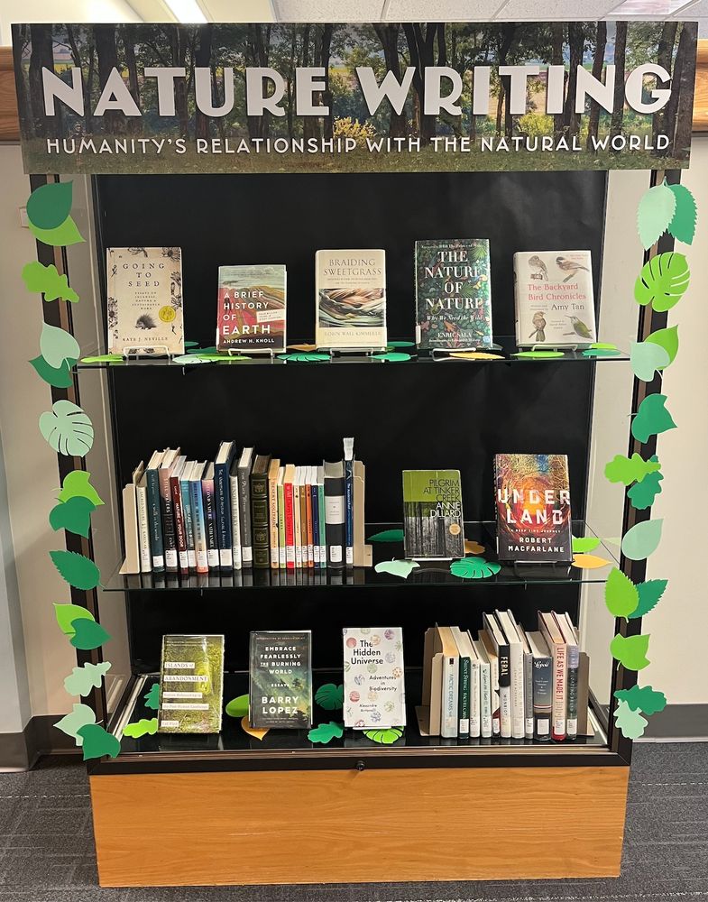 A photograph of a Nature Writing display of books with different style leaves around the border of the display.