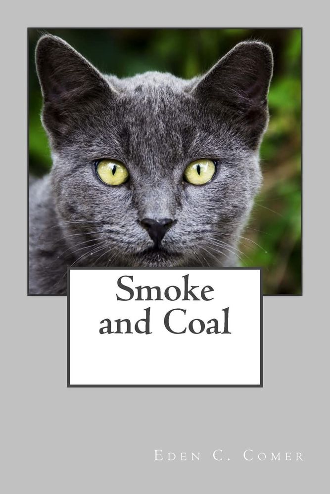 Book cover for Smoke and Coal by Eden C. Comer has a large photo of a gray cat with bright yellow eyes. The gray title is in a white text box.