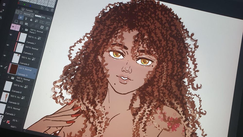 Foto da tela do ipad com o clipstudio paint aberto, mostrando o sketch colorido da personagem citada no post. Ela tem a pele marrom claro, olhos cor de mel, e cabelo cacheado longo, castanho com as pontas loiras. No ombro esquerdo tem umas flores de cerejeira tatuadas em vermelho. 