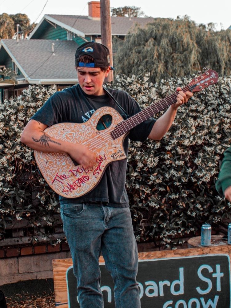 Sasha standing up playing guitar 