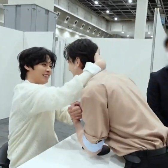stray kids lee know pulling chan in by his neck while holding hands