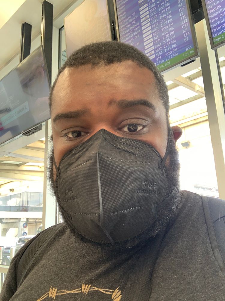 A pic of Kendo in the Airport wearing a black mask.