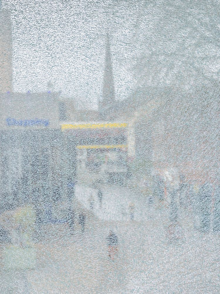 “Fragments” is an abstract figurative photograph, which uses a portrait orientation. It is encased by a texture which gives the work a fragmented and obscured appearance. The work includes impressions of people and architecture, with a spire being visible near the centre. The work is an everyday scene taken from a city centre on a quiet day with an overcast sky and pedestrians walking along an open walkway.
