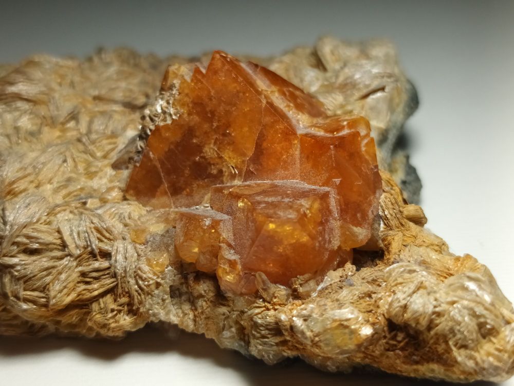 Orange crystals on a flaky-looking base rock.