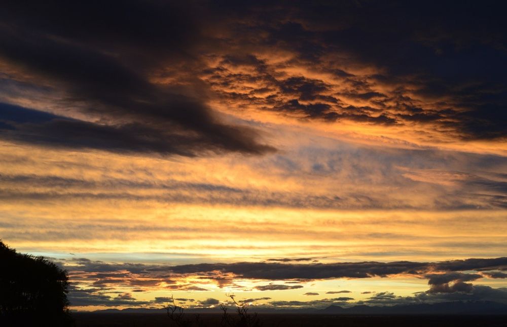 A photo of a sunset through norwester clouds over the Southern Alps as seen from the Cashmere hills of Christchurch city. The sun is below the horizon and the cloudy sky is lit up in orange.

My full-res photo is on Flickr at https://www.flickr.com/photos/mollivan_jon/54844913144/