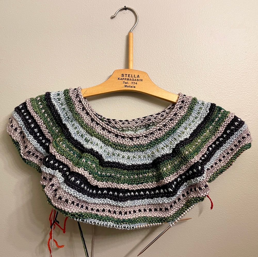 A striped top-down sweater where the sleeves have just been separated.