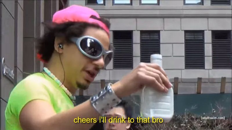 Eric Andre during a taping of The Eric Andrew Show dressed in a neon green shirt, pink hat & grey sunglasses drinking ranch dressing.