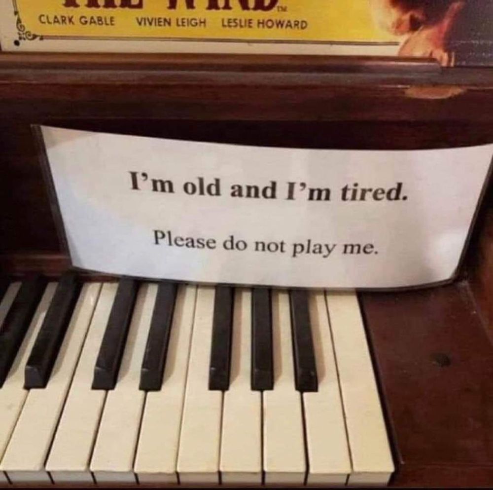 sign on antique piano saying I'm old and I'm tired do not play me