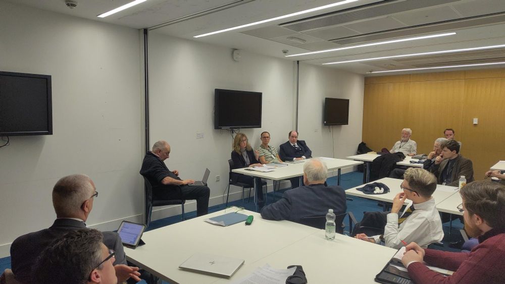 Gillian Black sits behind a desk and delivers a talk to the conference audience.