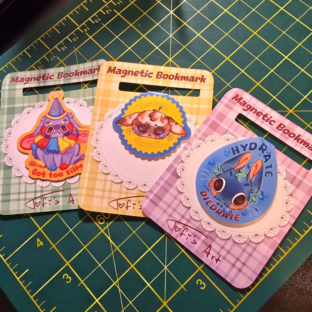 Magnetic bookmarks of cute bunnies in different colors. Clowncore bunny, certified crybaby bunny, and hydrate or diedrate bunny. On cute backing cards. Tofi's Art designs.