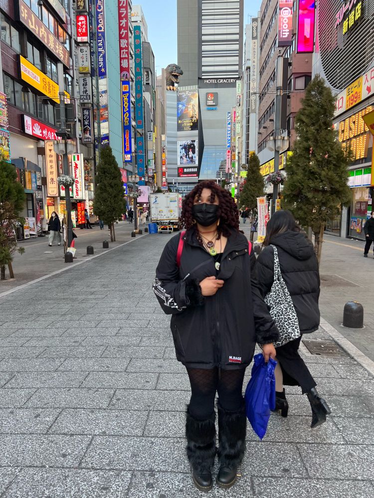 Woman wearing all black walking down a street in Japan