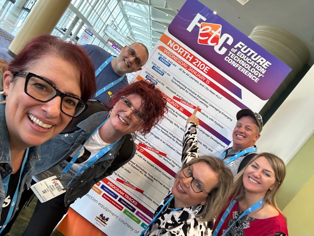 A group of people at an FETC board smiling
