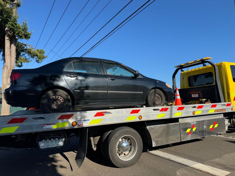My car on the back of a flat bed tow truck 