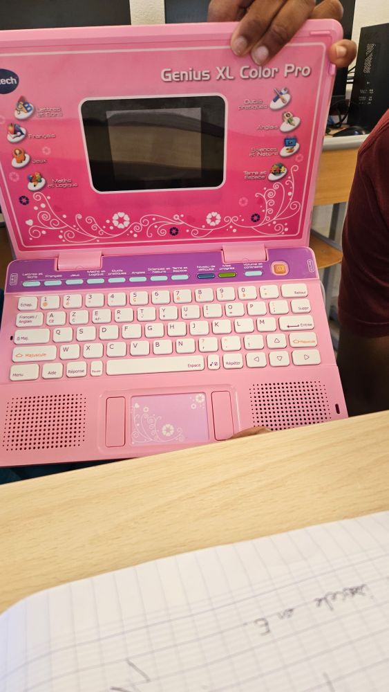 Photo d'un ordinateur portable d'enfant avec un tout petit écran. Il est rose avec des fleurs. Il est magnifique.