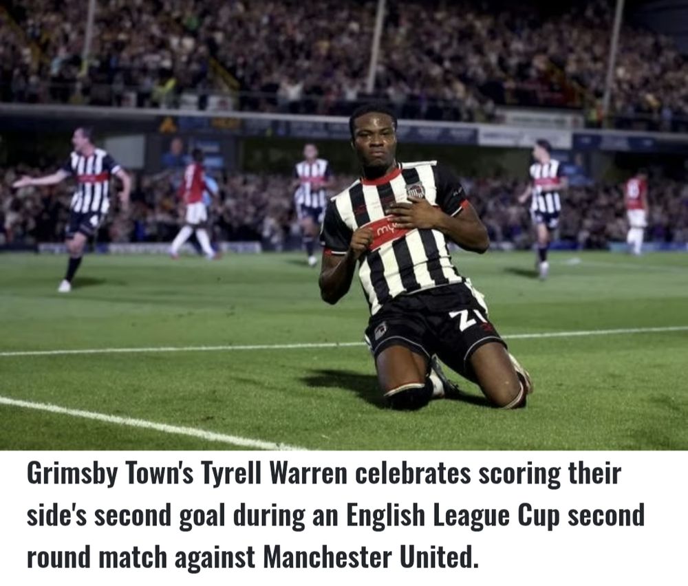 Grimsby Town player Tyrell Warren skids along the pitch after scoring the team's second goal against Manchester Utd in the Caribou Cup
