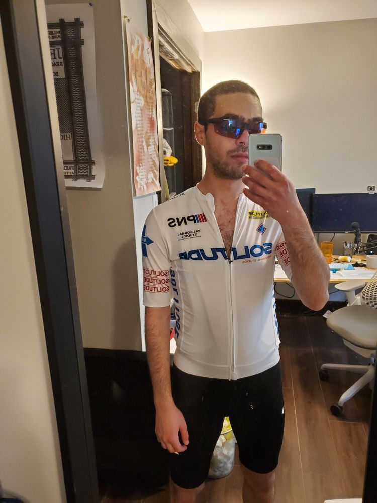 Me after a haircut wearing an athletic cycling outfit and sunglasses.