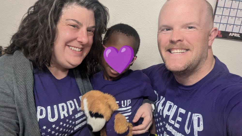 Three people wearing purple shirts that say Purple Up for Military Kids