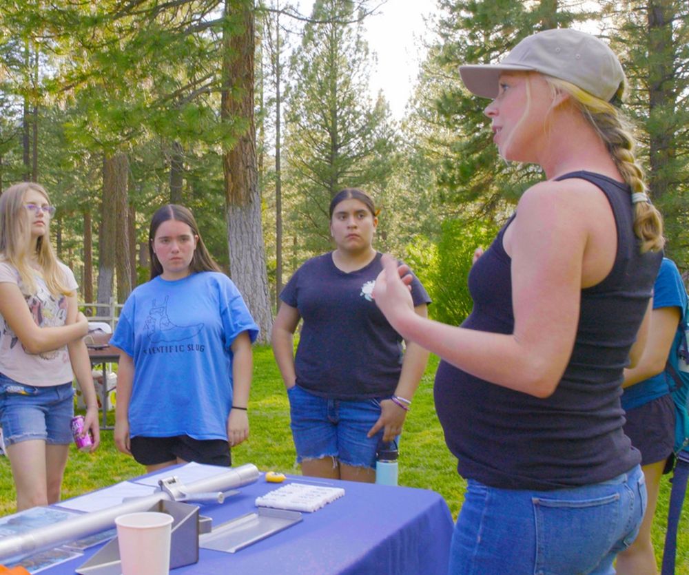 Scientist Anne Heggli explains snowpack science to three campers.