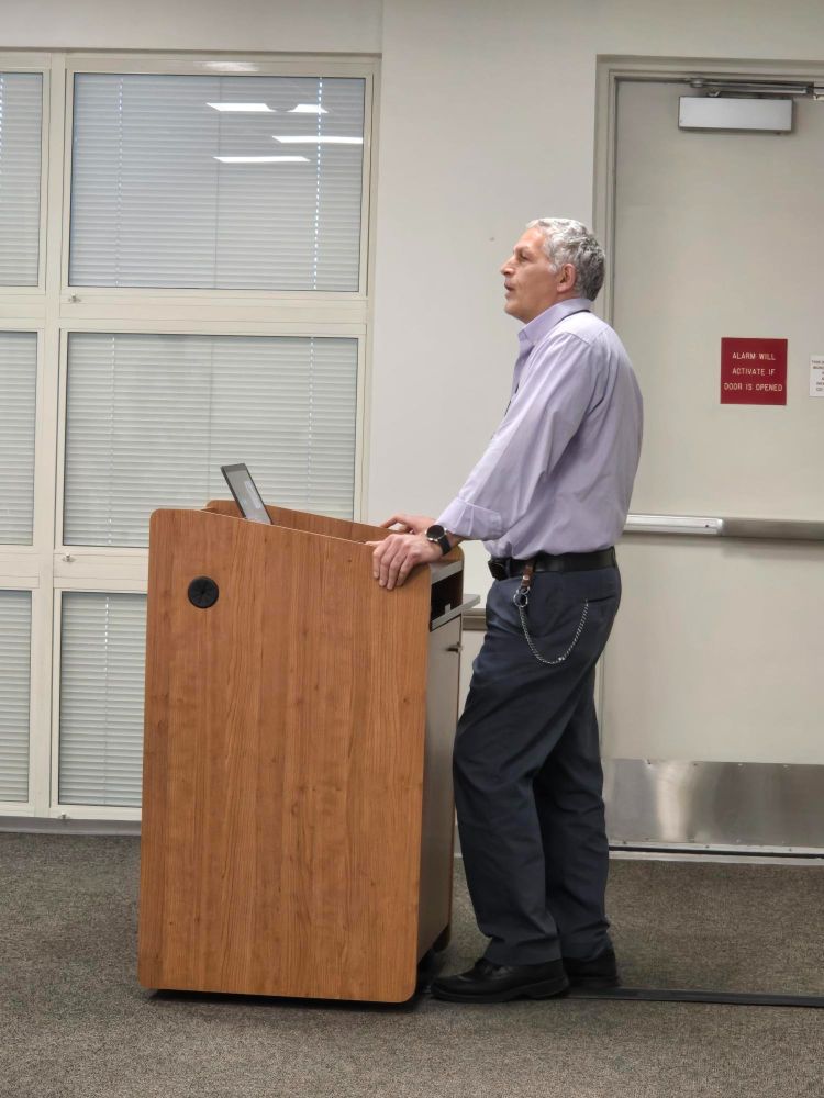 DRI Vice President for Research Vic Etyemezian stands behind a brown podium and speaks.
