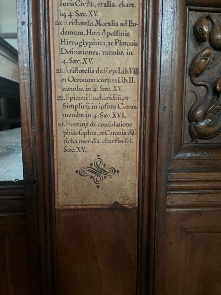 Close up of manuscript book list detailing books in each section (in latin)