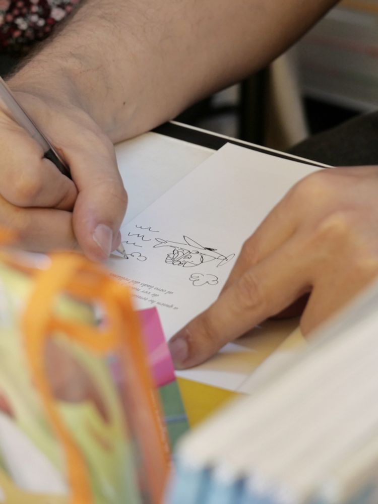 Firmando un ejemplar de Troti, en el que dibujo un "troti piloto"