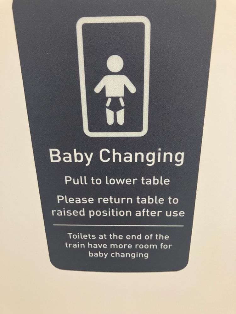 A photograph from a train n toilet informing that better baby changing facilities are at the other end of the train. 