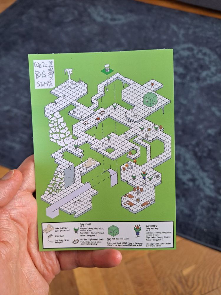 Postcard dungeon "Well of the Big Stompa" showing an isometric map with lil goblins in, and a key along the bottom.