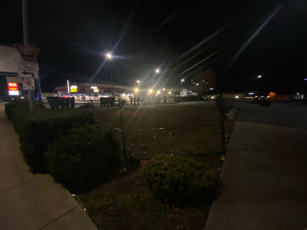 a night darkness picture of where the Abbotsford location of the International House of Pancakes once stood. Now a small fenced lot of zero purpose or revenue utility.