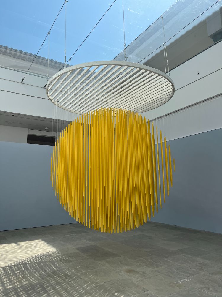 lames de métal suspendues créant une sphère jaune sous le toit d'eau de la fondation (Jesùs Rafael Soto)
