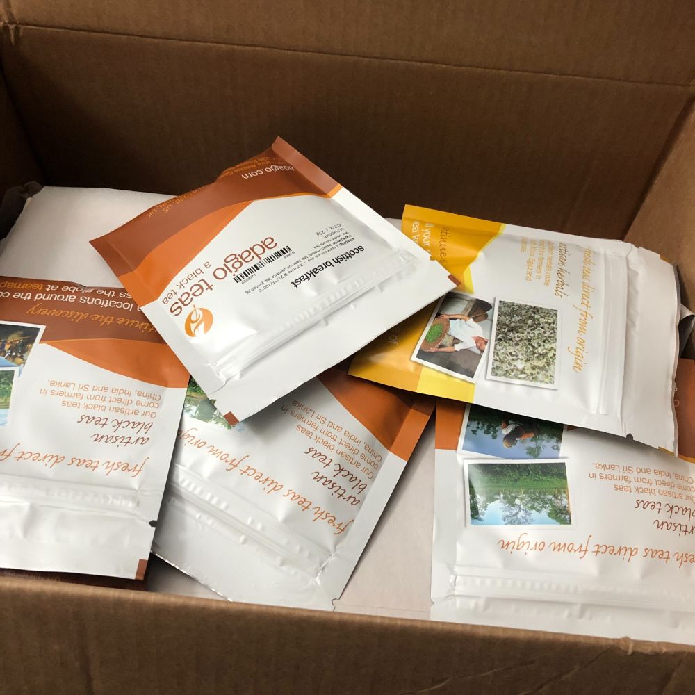 An open cardboard box with samples of tea in it