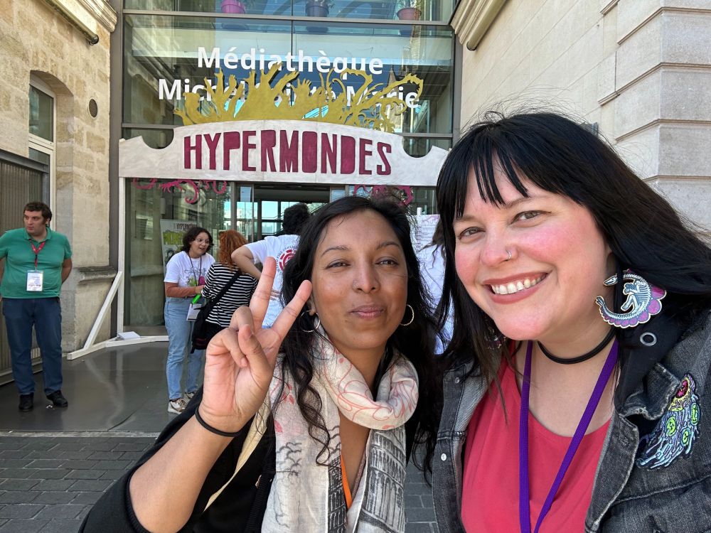 Two people pose outside of Hypermondes.