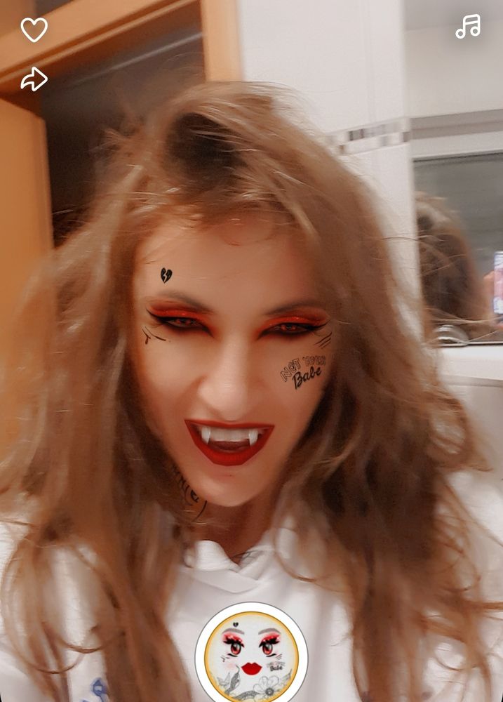 Ich, verwurstelte Haare, böse beissend schauende Grimasse, mit Snapchat Filter Vampir:
Rot schwarze Augen, Vampir Zähne,  rote Lippen, Gesichtstattoos.