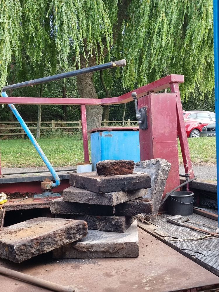 old flagstones used as ballast sitting on the back deck of a canalboat