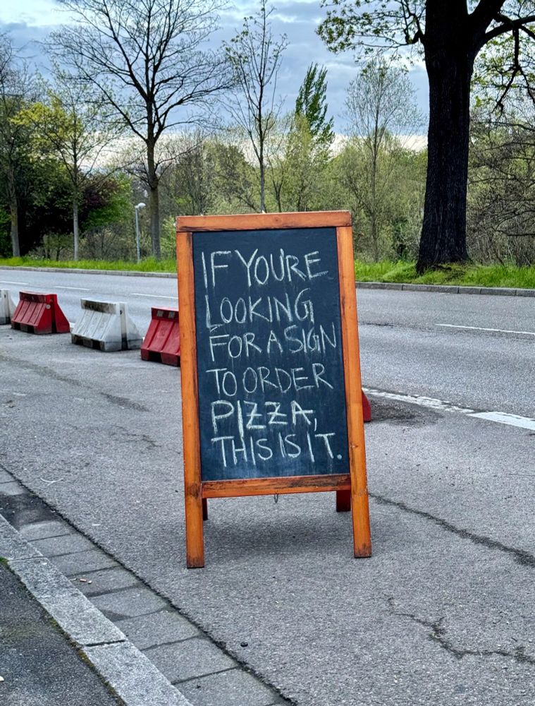 Tafel am Straßenrand mit der Aufschrift: If you‘re looking for a sign to order pizza:  This is it.