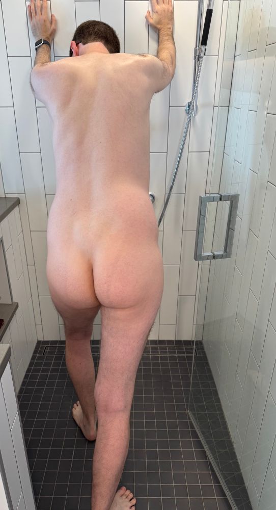 Me, naked, standing in the shower, hands against the wall, head lowered, one foot forward, ass in center frame 