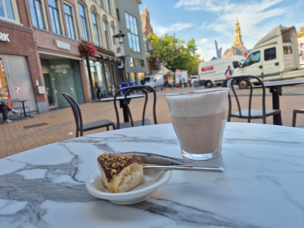 Chai latte and a quarter of a donut in front of the market in Groningen 