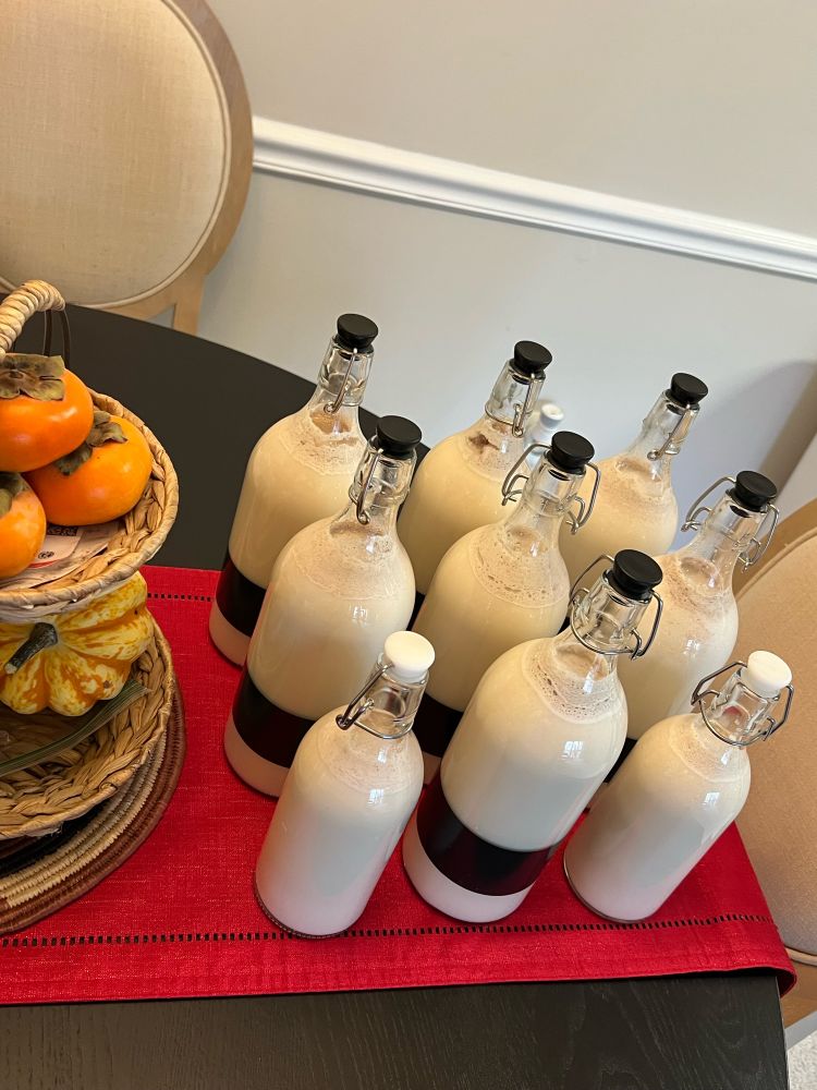 Nine bottles of Coquito with some persimmons and pumpkins on the side to mark the transition from Fall to Winter! 