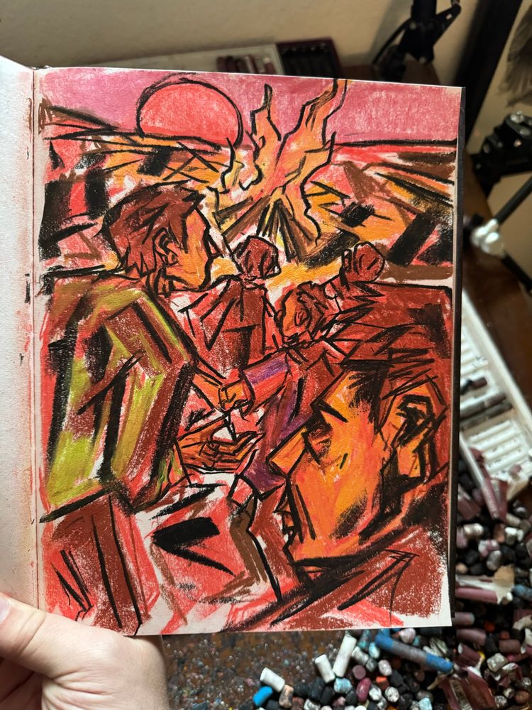 A hand holds a hardbound sketchbook open over an artist’s desk. Inside the book is a conte crayon sketch of figures running towards a fire with a setting sun as backdrop. Art by Jason Thomas Pitzl. 