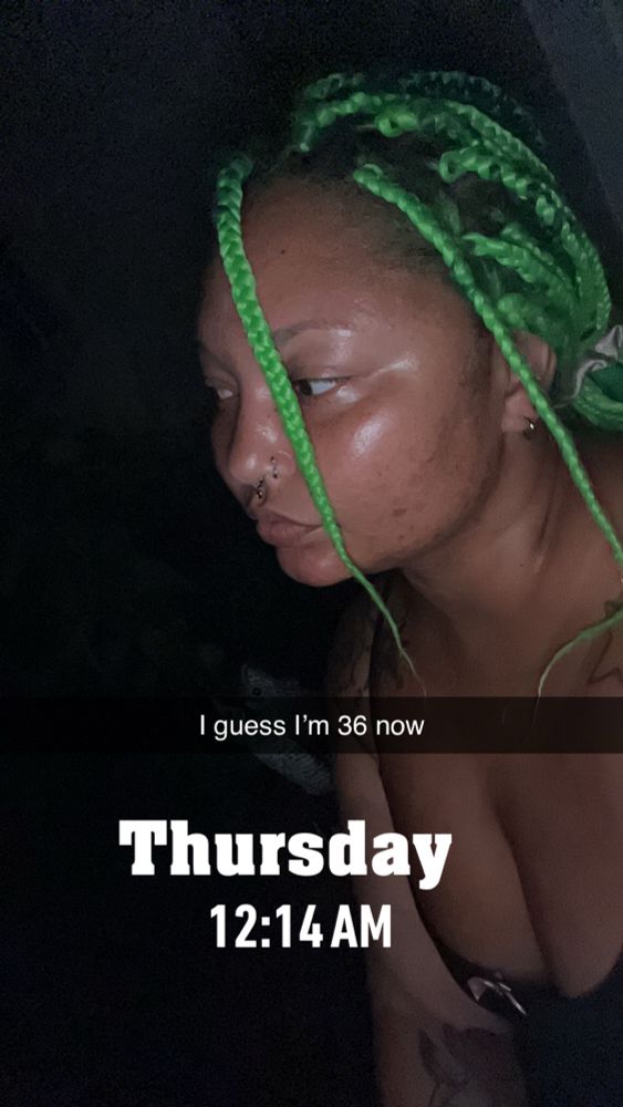 Selfie sitting on my porch in the dark. No makeup. Black tank top. Two green braids in front of my face. Text says “I guess I’m 36 now” text below says Thursday 12:14am