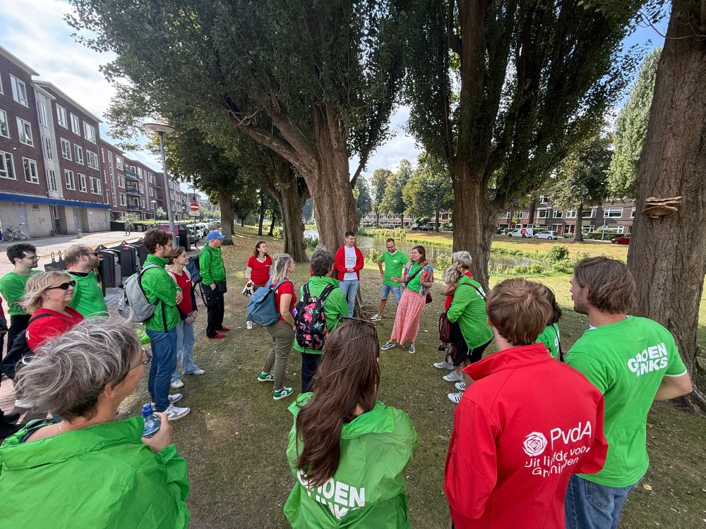 Groep van rond 30 huis aan huizers van GroenLinks-PvdA aan de Gorechtkade in Groningen. Zicht op vijver en bomen. 
