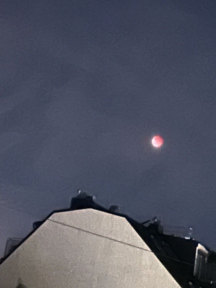 Die Dichel zeigt sich wieder, der Rest des Mondes ist rot. Im Vordergrund eine weiße Hausmauer.