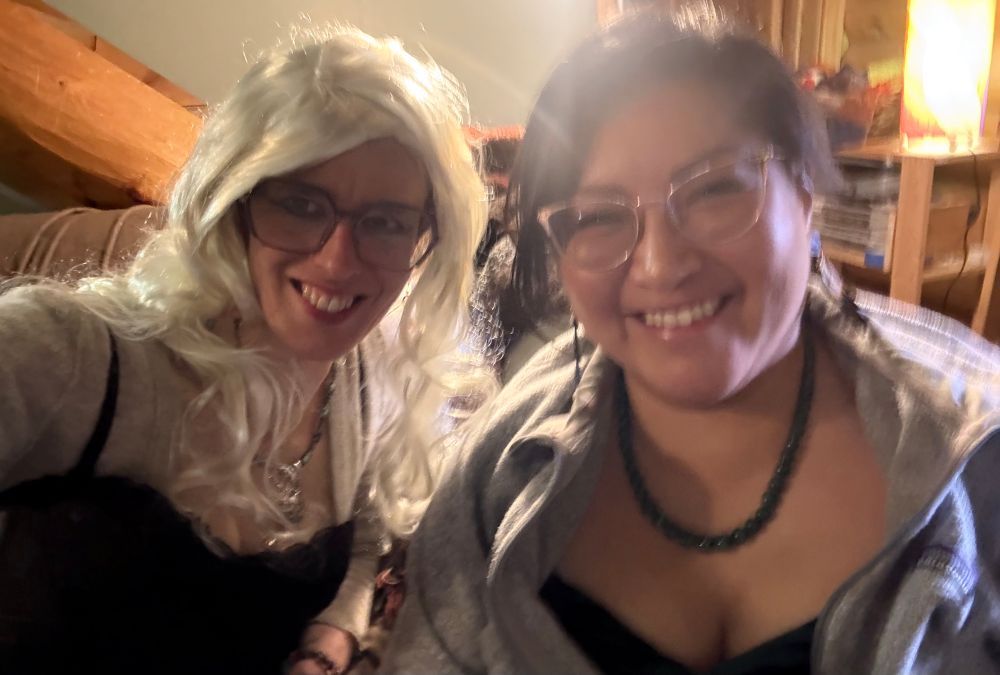 2 dressed up femmes in a house, in bad lighting, waiting for a ride 