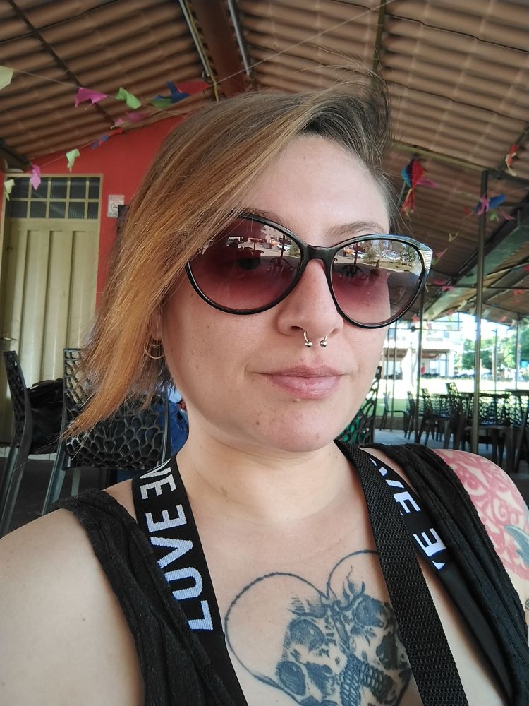 Selfie minha colorida estou sentada em um bar de óculos de sol e cabelo cor de vira lata caramelo 