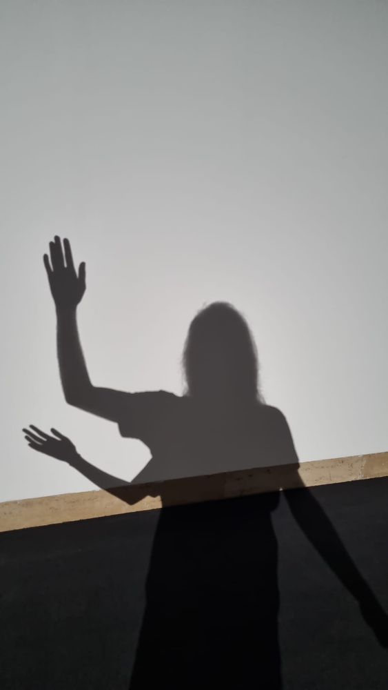 schatten einer winkenden person mit drei armen 