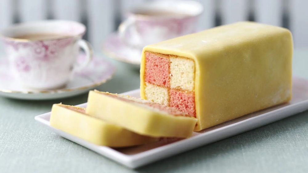 Battenberg cake - marzipan covered cake. The cake is squares of pink and plain.