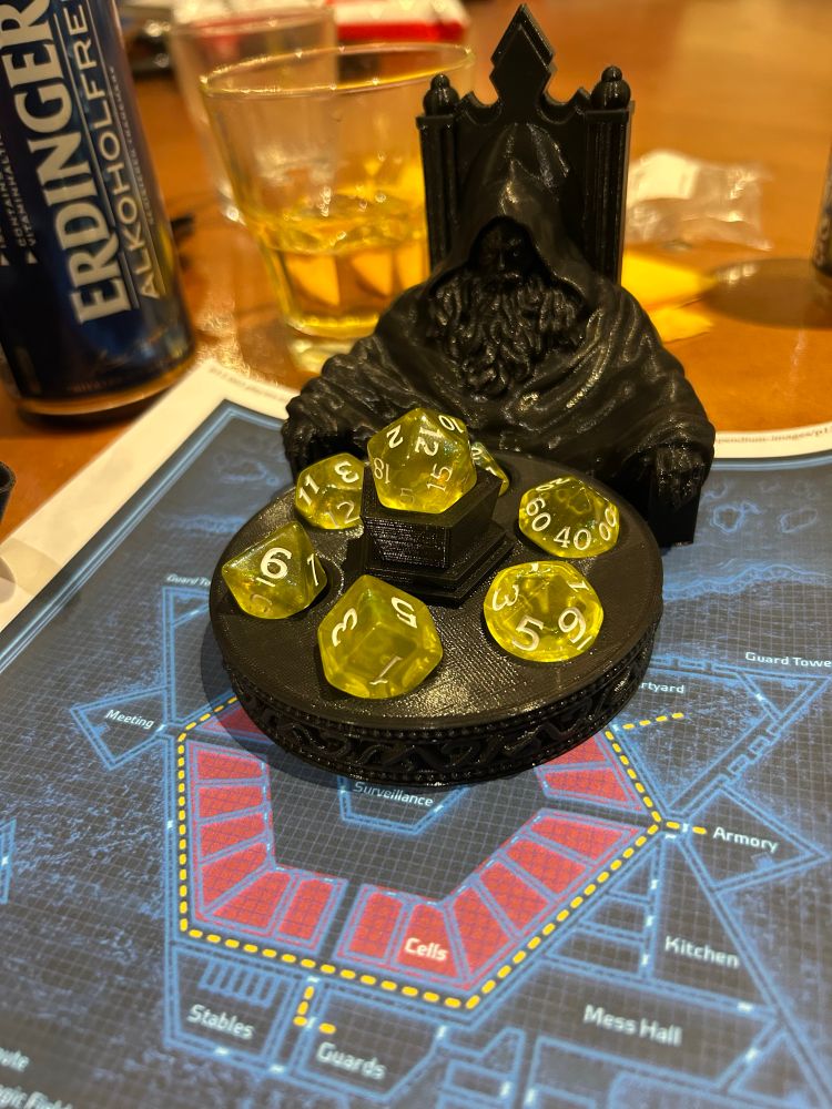 頭巾を被った魔獣師が円卓に座って水晶を見つめているデザインのダイスホルダー。水晶を置く場所にダイスを入れます