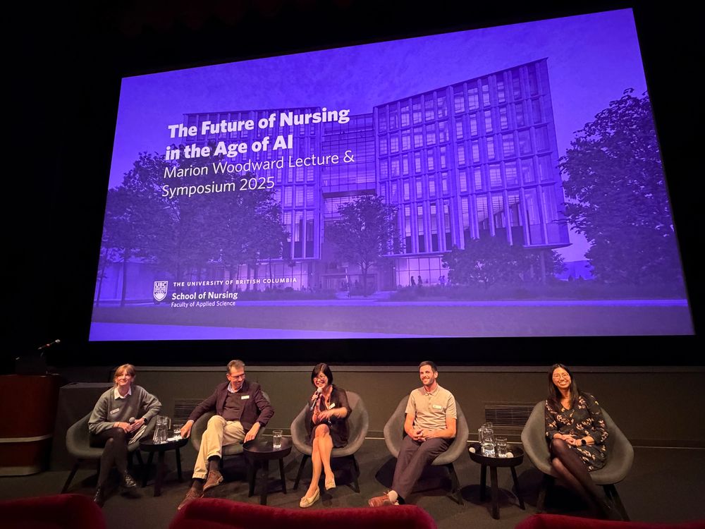 Five panelists seated on stage in front of a large purple screen displaying ‘The Future of Nursing in the Age of AI – Marion Woodward Lecture & Symposium 2025, The University of British Columbia, School of Nursing.’ From left to right: Dr. Emily Jenkins (chair), Dr. Bernie Garrett, Dr. Lillian Hung speaking into a microphone, Prof. Ash Scott, and Dr. Charlene Chu, who later delivered the keynote lecture.